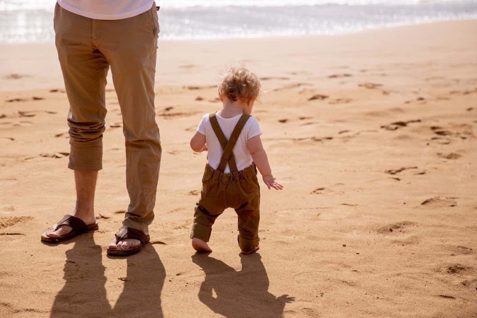 Bebê andando na areia da praia