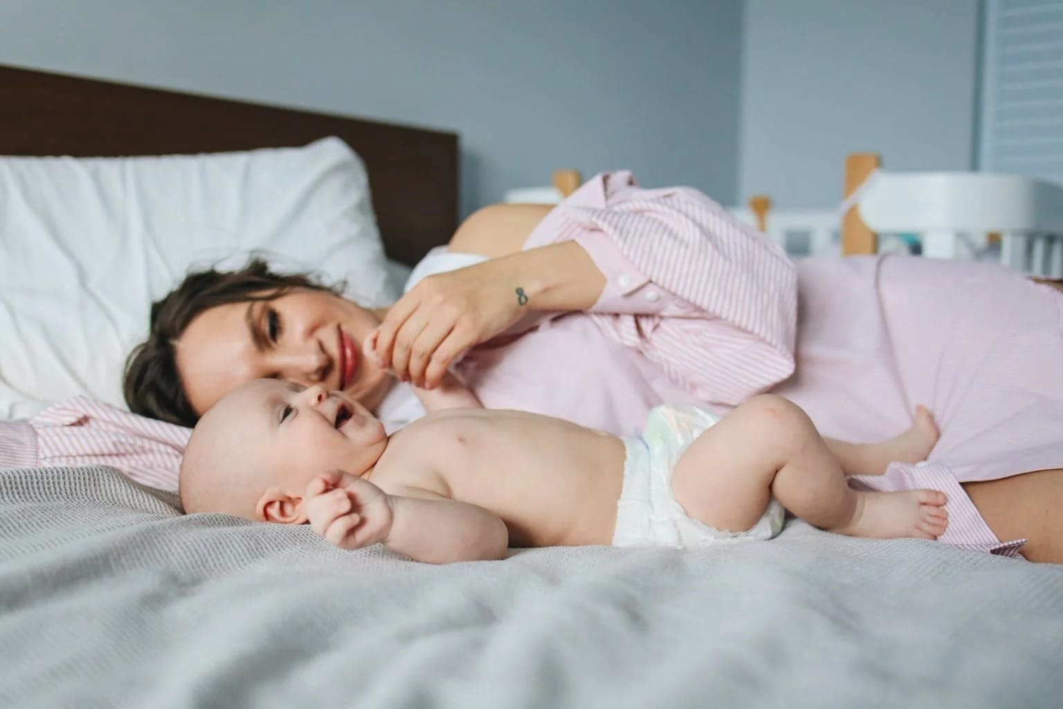 Mulher deitada na cama com bebê