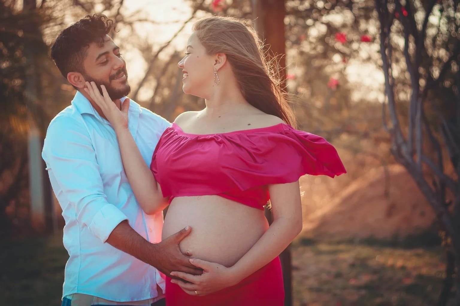Homem com a mão na barriga de mulher gravida