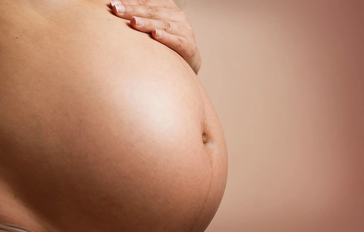 Grávida com a mão na barriga
