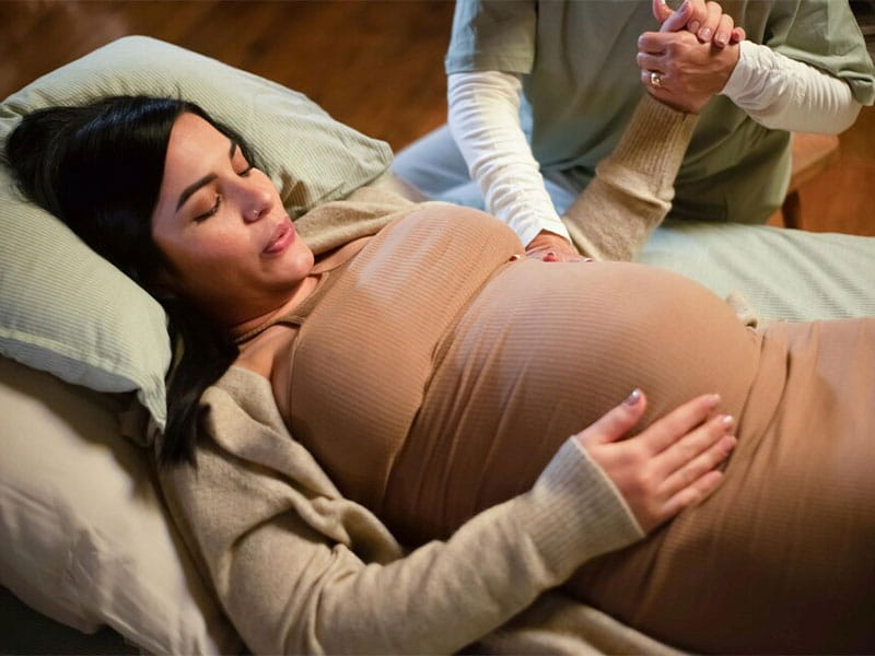 grávida deitada com a mão na barriga