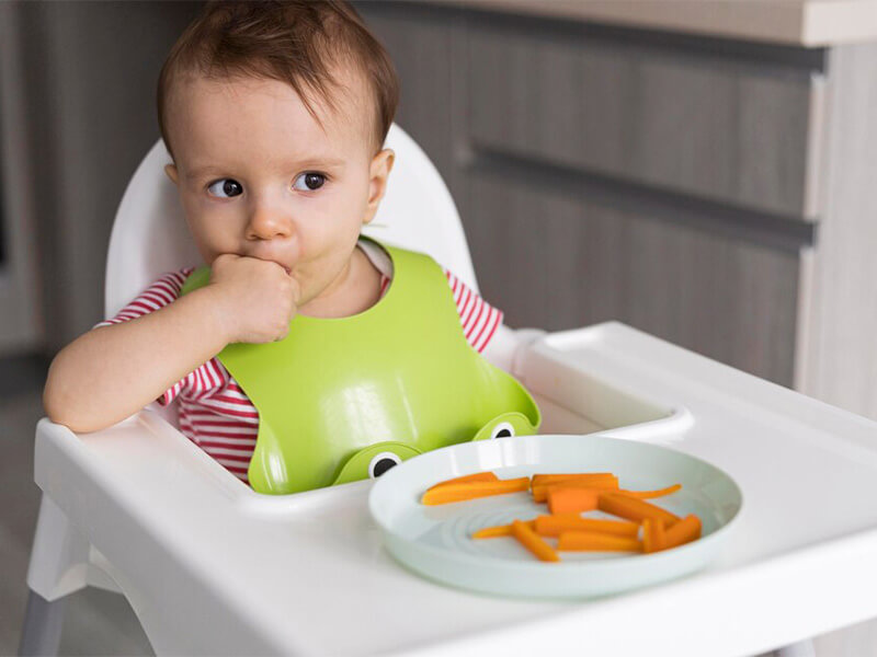 Criança comendo cenoura