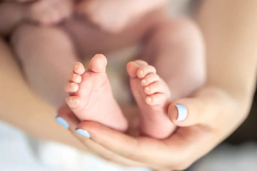 closeup feet newborn hands mother