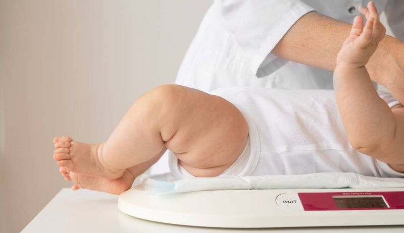 Criança sendo pesada em balança infantil