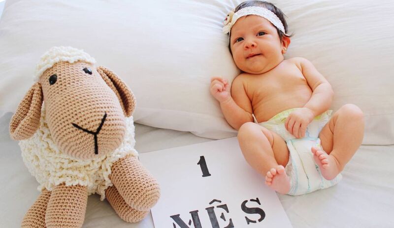 Bebê de 1 mês ao lado de um bichinho de pelúcia