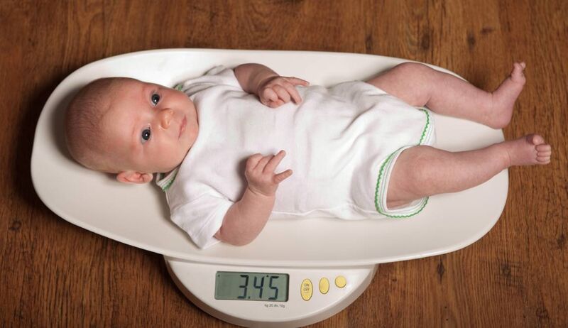 Bebê pesando 3,45 kg em balança digital