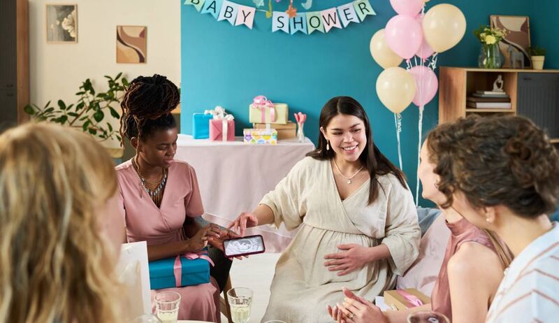 Mulheres celebrando um chá de bebê em casa.