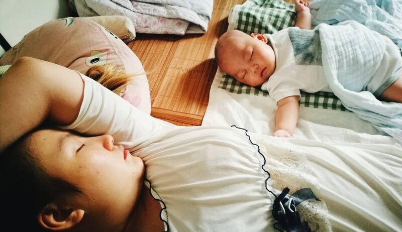 Mãe e bebê dormindo tranquilamente juntos