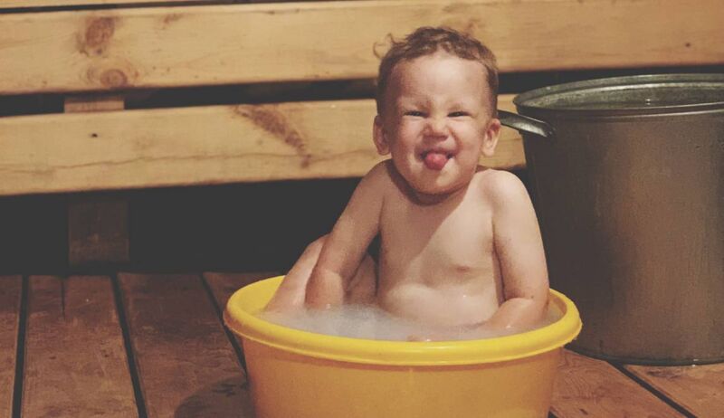 Criança sorrindo em banho de espuma